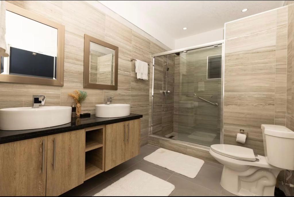 a bathroom with a toilet and a sink and a shower at Luxury Bliss in Runaway Bay