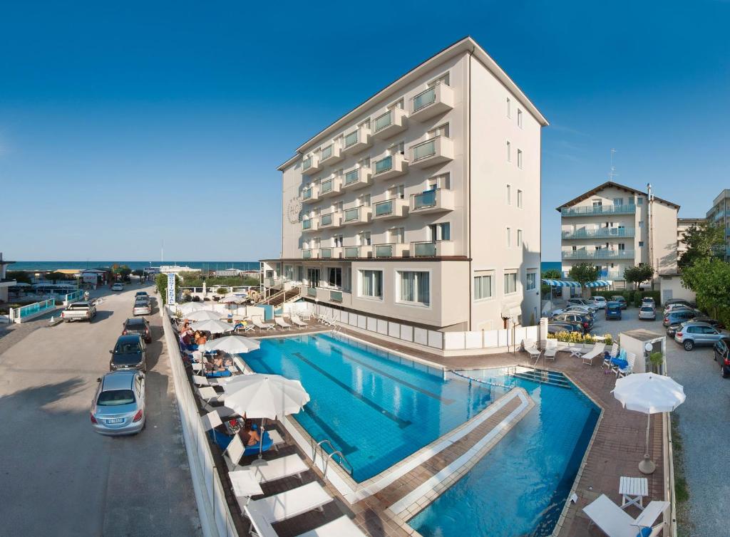 ein Hotel mit einem Pool vor einem Gebäude in der Unterkunft Hotel Continental in Milano Marittima