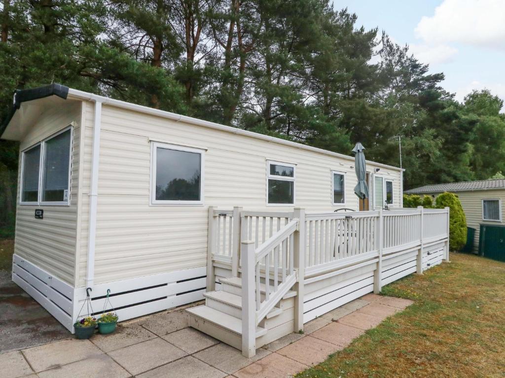 a white tiny house with a porch at Foxglove 4 in Ringwood