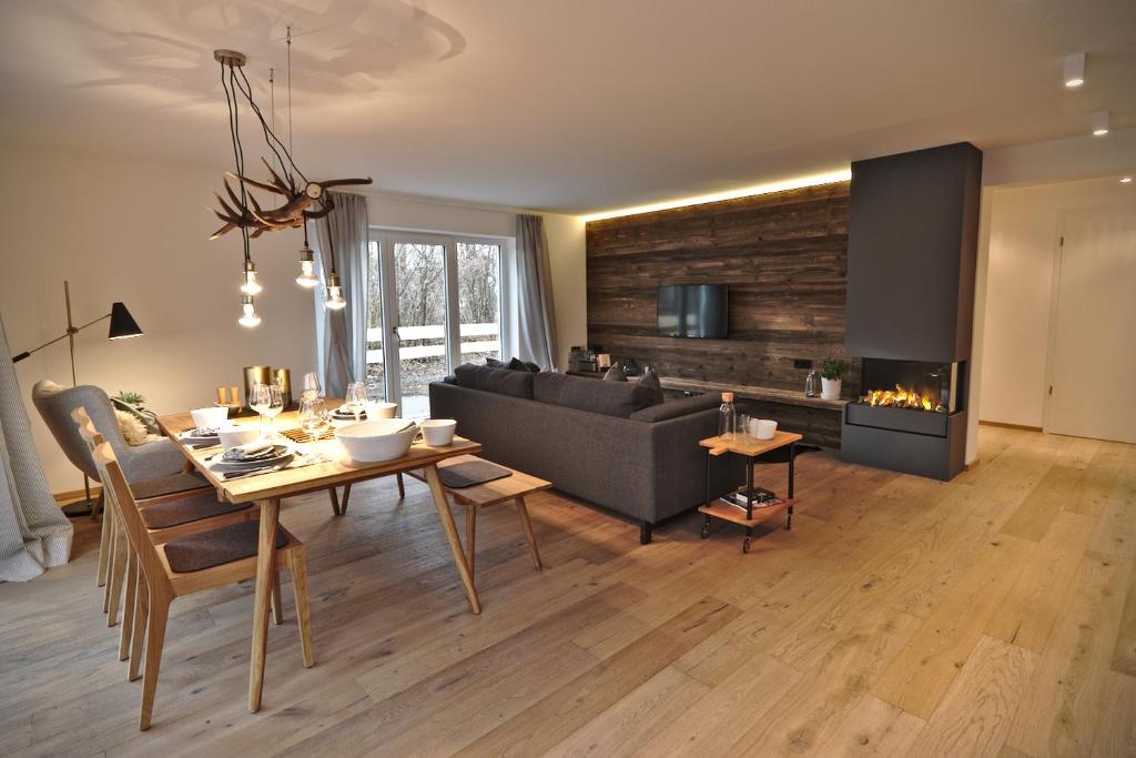 a living room with a couch and a table and a fireplace at Das Alpiente - Das Urlaubshaus im Allgäu in Sonthofen