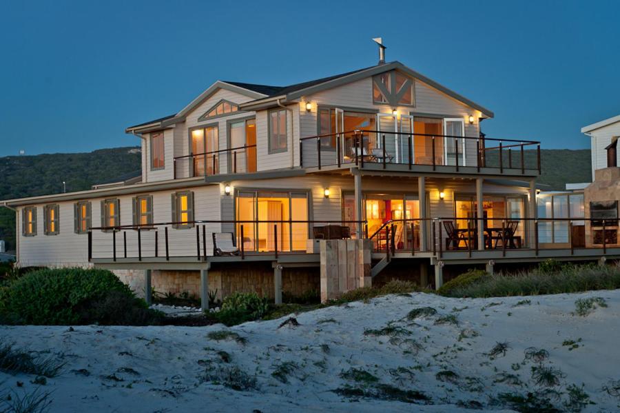 a large house on the beach at night at Dune Rose in Yzerfontein
