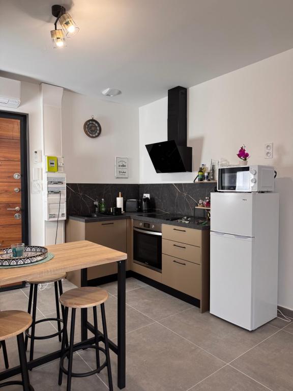 a kitchen with a table and a white refrigerator at 103 - Voiron centre - DeTassigny in Voiron