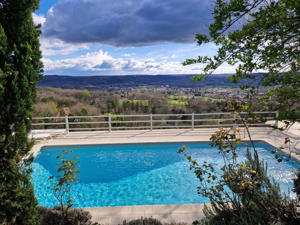 a swimming pool with a view of the city at le clos des etoiles B&B in Le Bugue