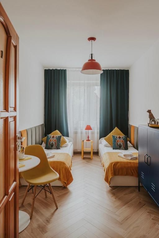 a hotel room with two beds and a table at Cztery Kąty Zator Energylandia Przeciszów in Przeciszów