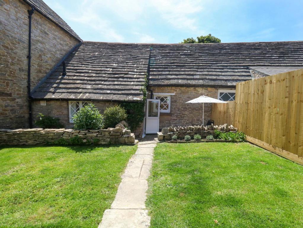 a brick house with an umbrella in a yard at Sea Pink Cottage in Swanage