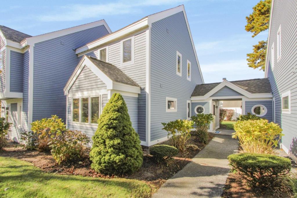 a house with blue siding and a driveway at Coastal Cozy in Brewster