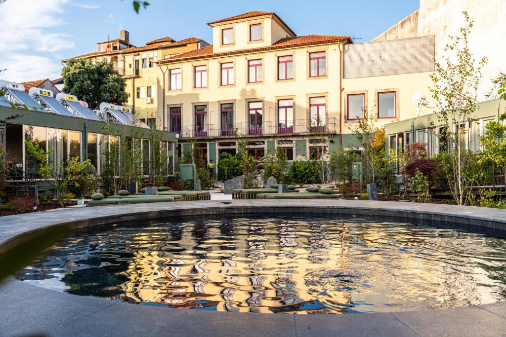 a large pool of water in a courtyard with buildings at chic&basic Tokyo Hoose in Porto