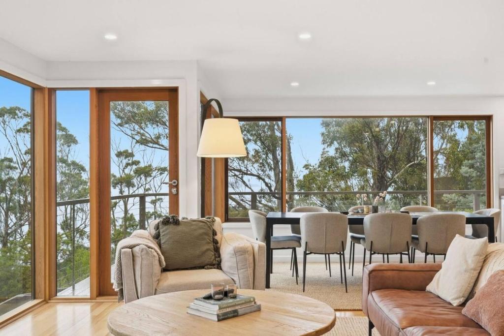 a living room with a table and a dining room at Bush Escape with Water Views in Tinderbox