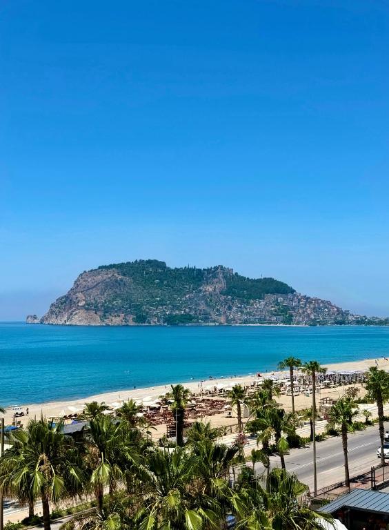 a view of a beach with palm trees and the ocean at SA Apartments! Beachfront Apartments in Oba in Alanya