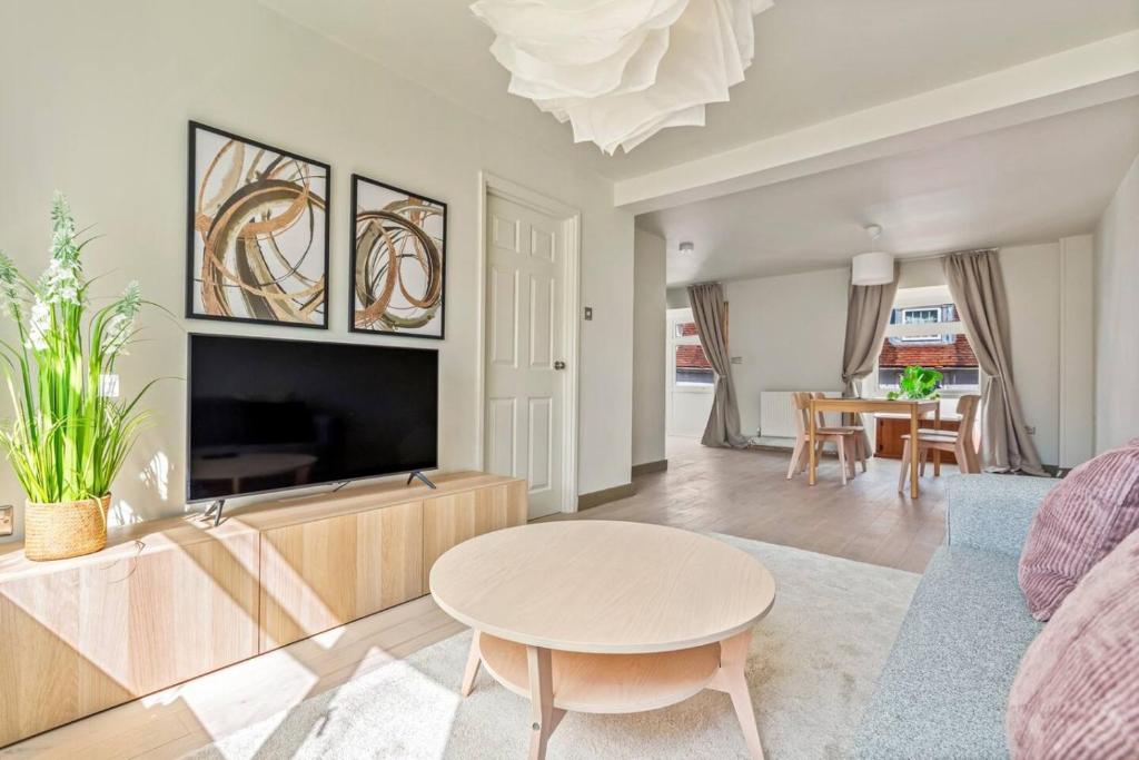 a living room with a table and a tv at Smart TV, Nespresso machine, Self Check-In in Potter Street