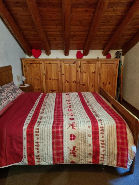 a bedroom with a bed with a red and white blanket at Chalet Silence - Grand Haury in Auri Grande