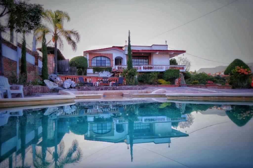 a house with a reflection in a pool of water at Hotel Colonial Taxco in Taxco de Alarcón