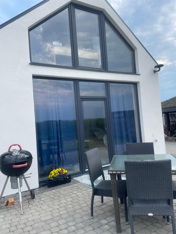 a patio with a table and chairs and a house at AgroReset in Korlino