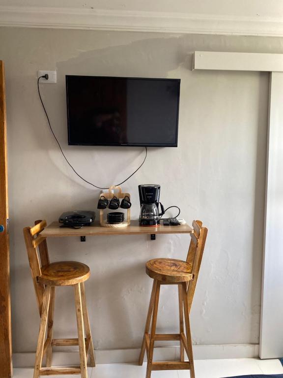 a table with two chairs and a tv on a wall at Antigo hotel murubira in Belém