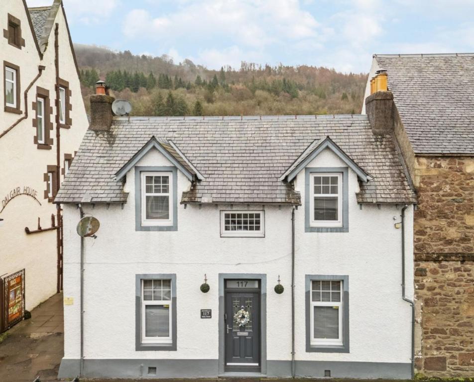 a white house with a gray roof at Dunella Traditional Cottage in Callander