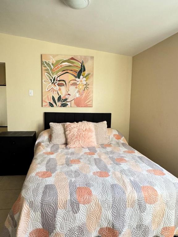 a bedroom with a bed with a painting on the wall at Estudio #4 a 5 min del malecon in La Paz
