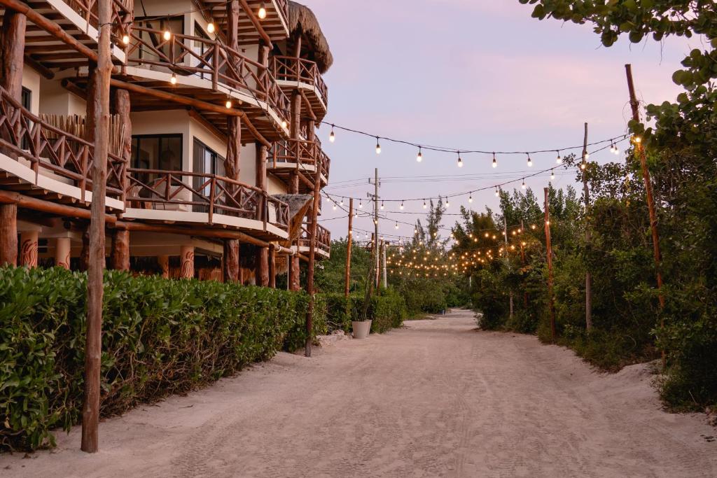 a dirt road in front of a building with lights at Casa Astral Hotel Boutique and Apartments in Holbox Island