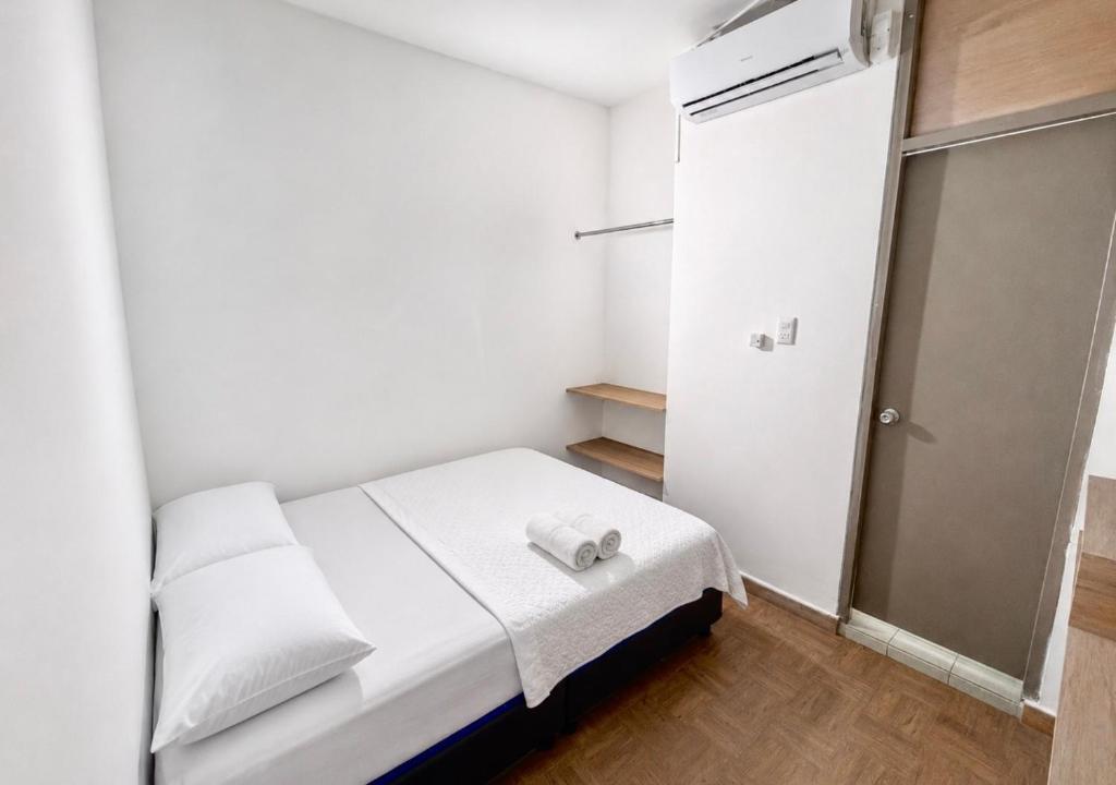 a small room with a bed and a refrigerator at Ocean Blue Suites & Hotel Sm in Santa Marta