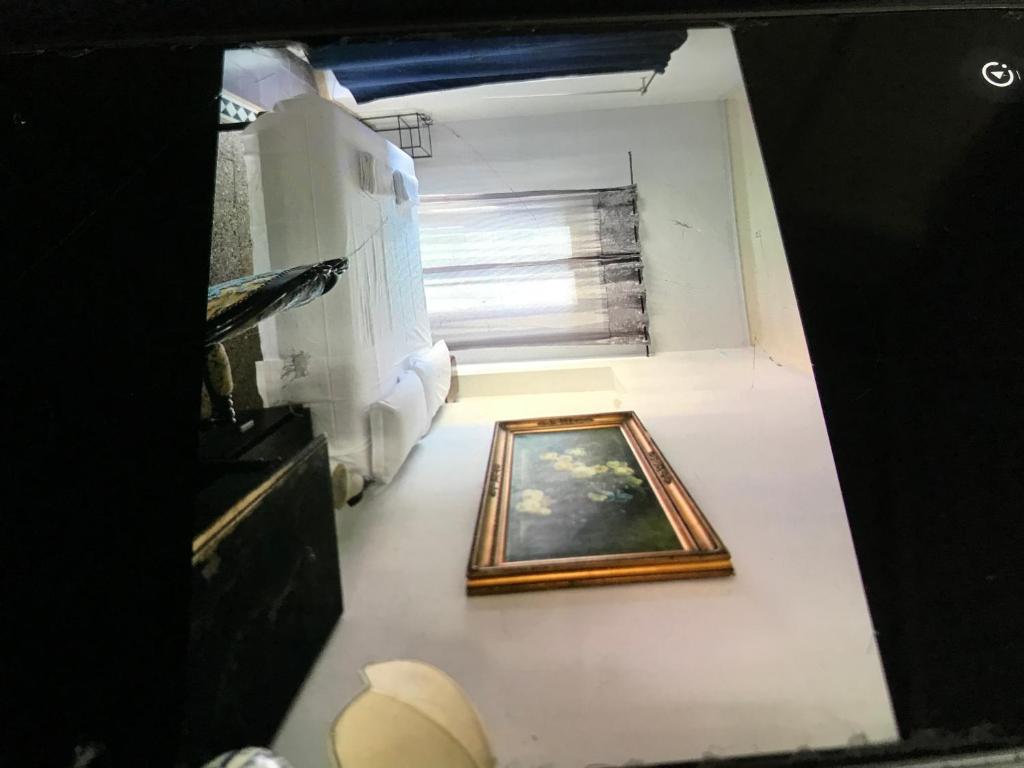 ein Gemälde auf dem Boden eines Zimmers mit Fenster in der Unterkunft Blu in Pisa
