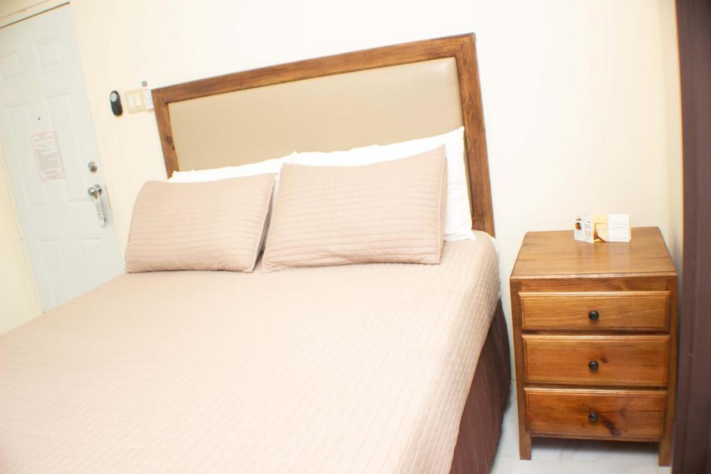 a bedroom with a bed and a wooden night stand at The Vista Inn Studio #1 in Falmouth