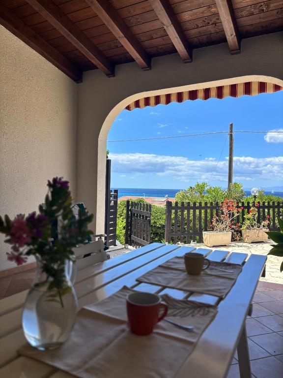 a table with a vase of flowers on a patio at Splendida villetta Kal'e Moru in Marongiu