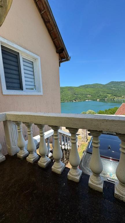 a balcony of a house with a view of the water at Perućac - Apartman sa pogledom na jezero in Perućac