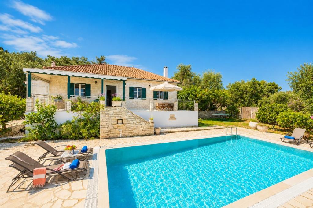 a villa with a swimming pool and a house at Villa Afroditi in Kourtaíïka