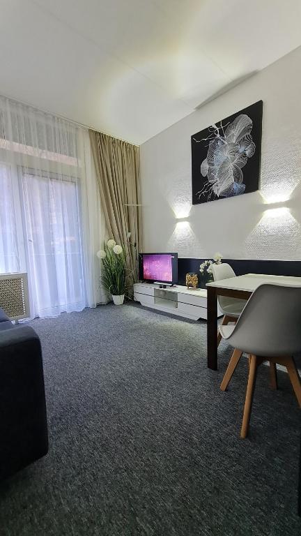 a living room with a table and a tv at Ferienwohnung Kamerer in Bad Harzburg