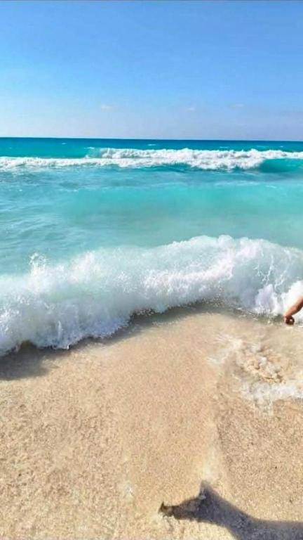 a person standing on a beach near the ocean at Biu Bela abartment hotel in El Alamein