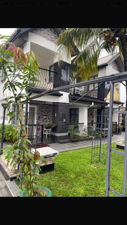 a house with a palm tree in front of it at Sandvica Luxe Homes in Port Harcourt