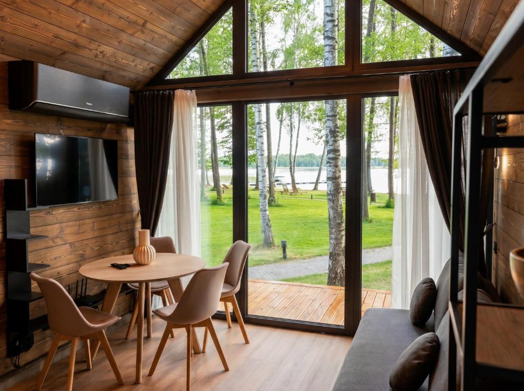 a room with a table and chairs and a large window at Beržų oazės spa in Molėtai