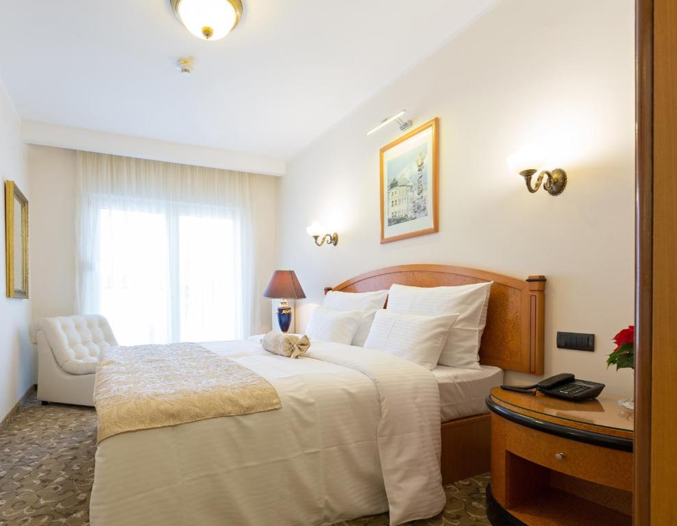 una habitación de hotel con una cama con un animal de peluche. en Hotel Sterling Garni, en Belgrado