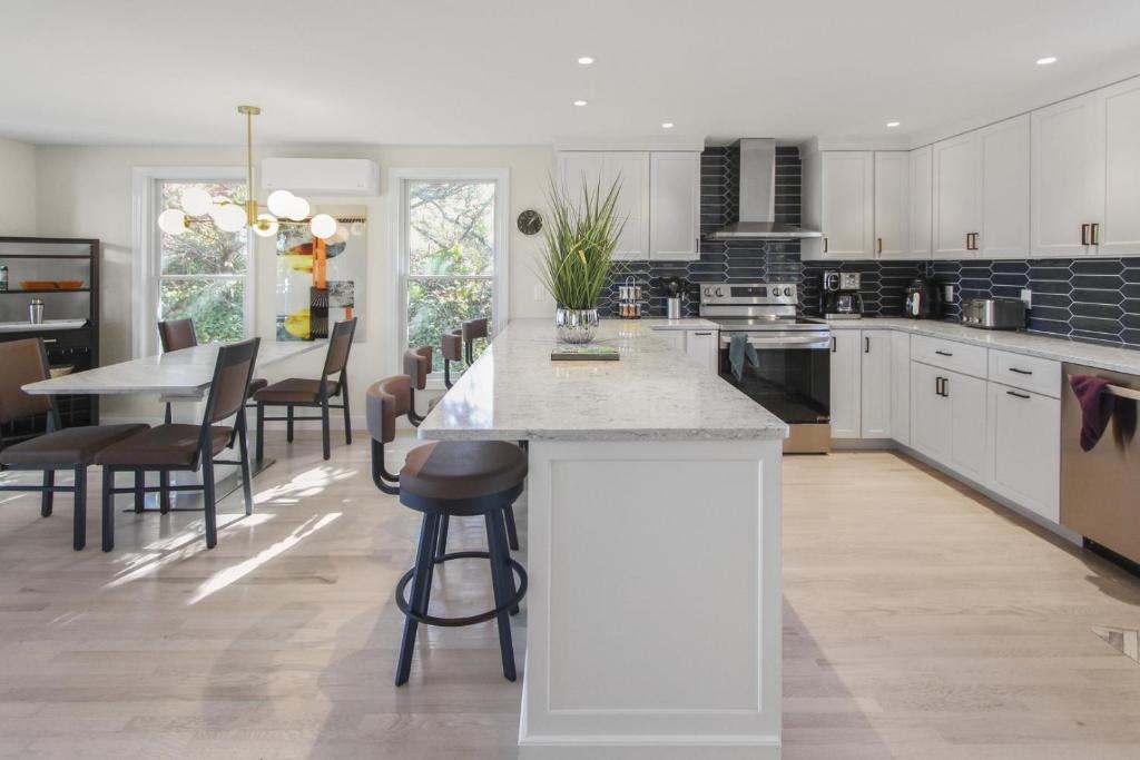 a kitchen with white cabinets and a table and chairs at The Viewpoint in Provincetown