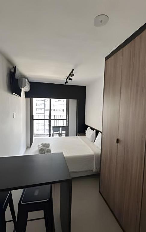 a bedroom with a bed and a desk and a window at Studio 810 | Completo e Novo | SP Expo e Congonhas in São Paulo