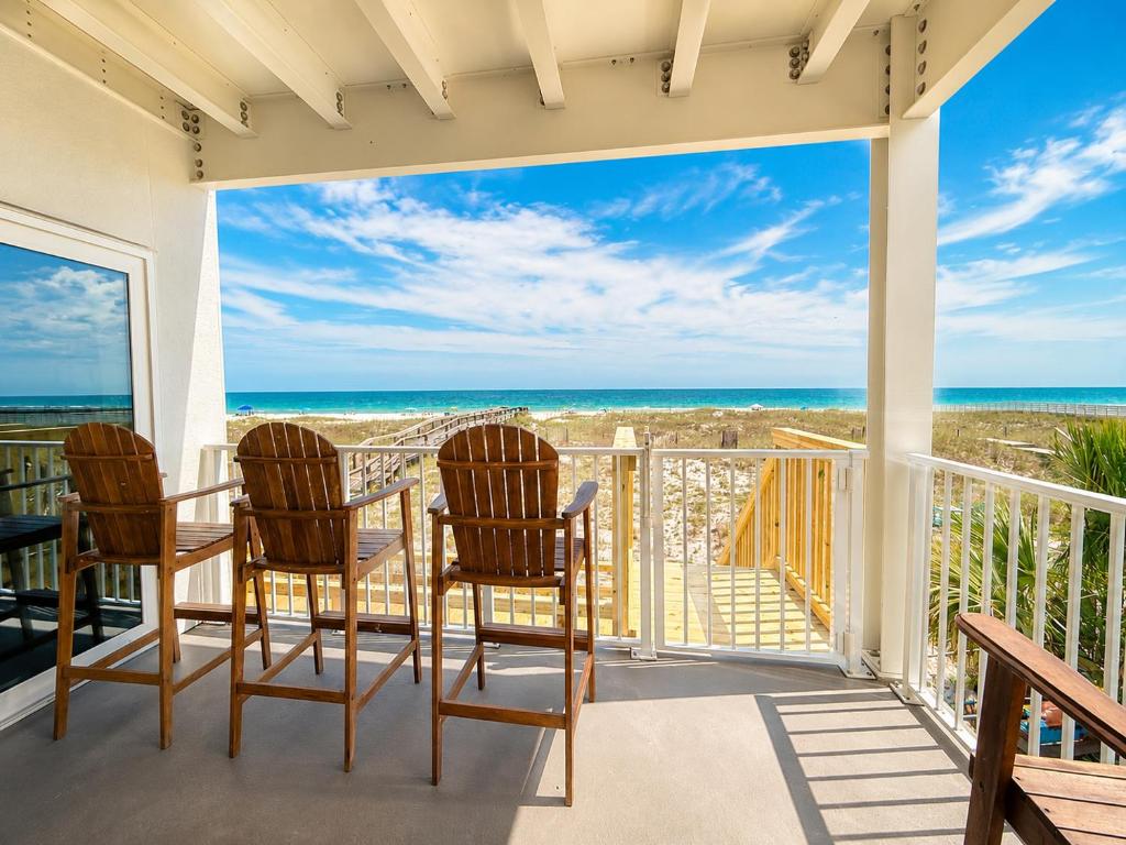 a porch with chairs and a table and a view of the ocean at Perdido Key Beachfront 4BR Sleeps 12 Steps to the Beach Sweeping Gulf View in Pensacola