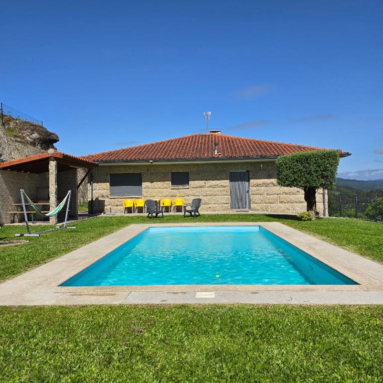 a swimming pool in front of a house at Casa da Batoca - Rossas in Vieira do Minho