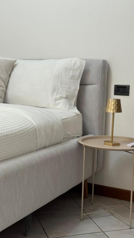 a white couch with a side table and a lamp at Terra intelvi in San Fedele Intelvi
