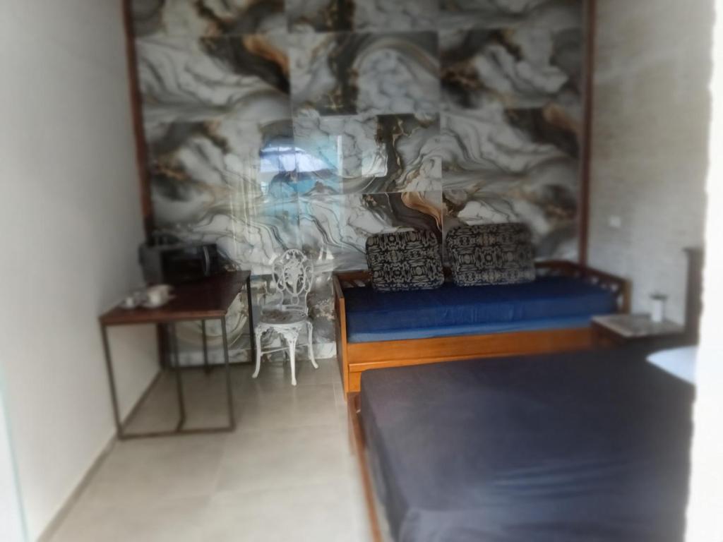 a room with a bed and a table and a wall at Suites perto praia in Ubatuba