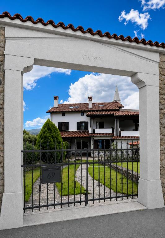 an archway in front of a house with a yard at Guest House Žerjal in Podnanos