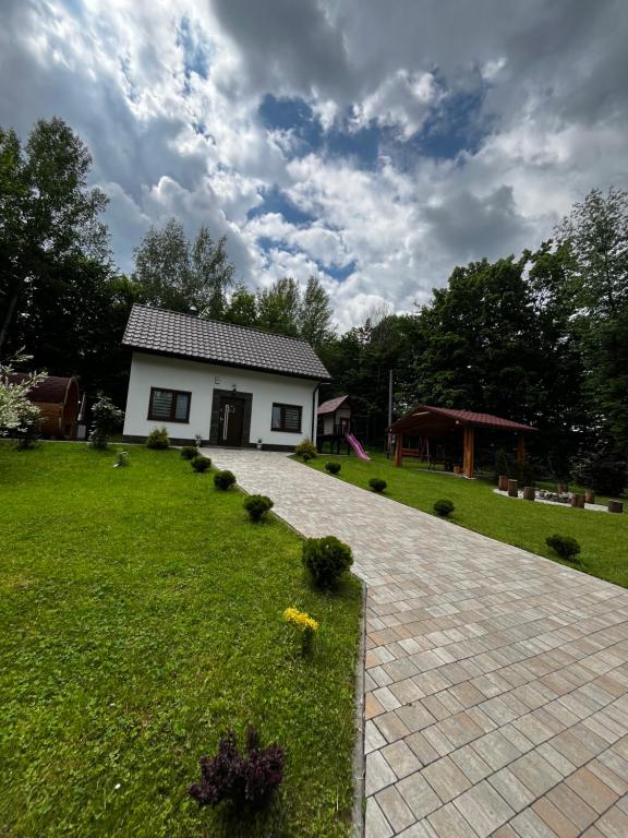 a house in a yard with a green lawn at Domek w lesie Sauna i Gorąca balia Wellness&Spa in Grybów