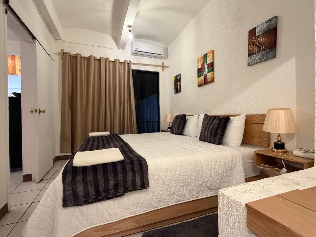 a bedroom with a large bed and a window at Suites Xico Oaxaca in Oaxaca City