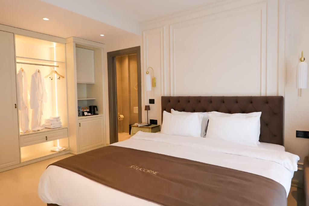 a bedroom with a large bed and a closet at Licorne Suites in Tirana