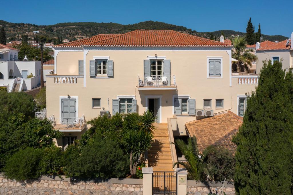 a large white house with trees in front of it at Mimoza in Spetses