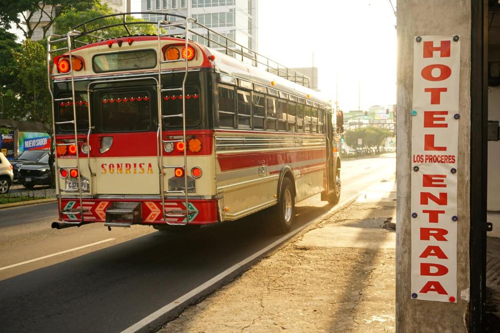 a school bus driving down a city street at Hotel Los Proceres in La Aurora