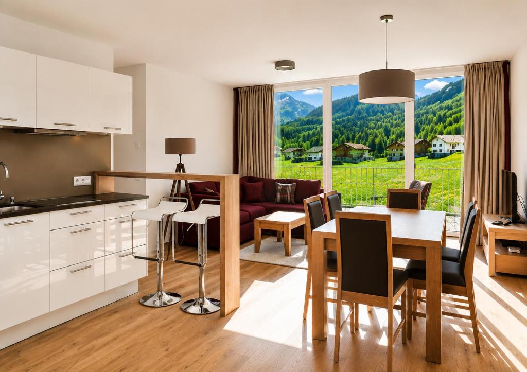 a kitchen and living room with a table and a couch at Silva Peak Residences Galtür in Galtür