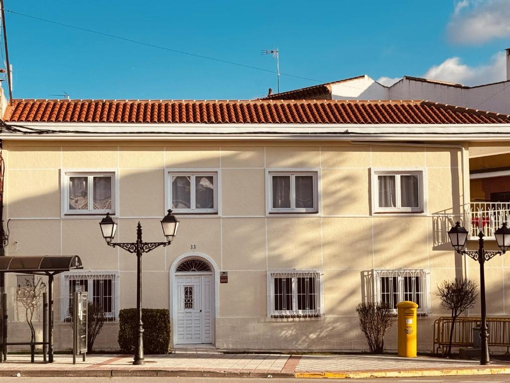 a white house with two lights on a street at La Villa Toledana in Cabañas de la Sagra