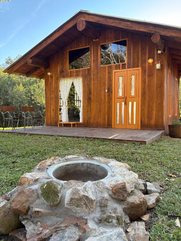 a log cabin with a fire pit in the yard at Chalé Do Lago in Garibaldi