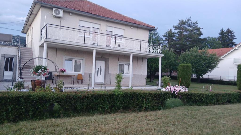 a large house with a balcony and a yard at Zgona in Livno