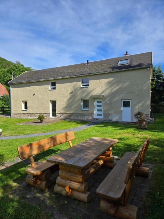 a picnic table and bench in front of a building at Am Rittergut Giesenstein in Bad Gottleuba