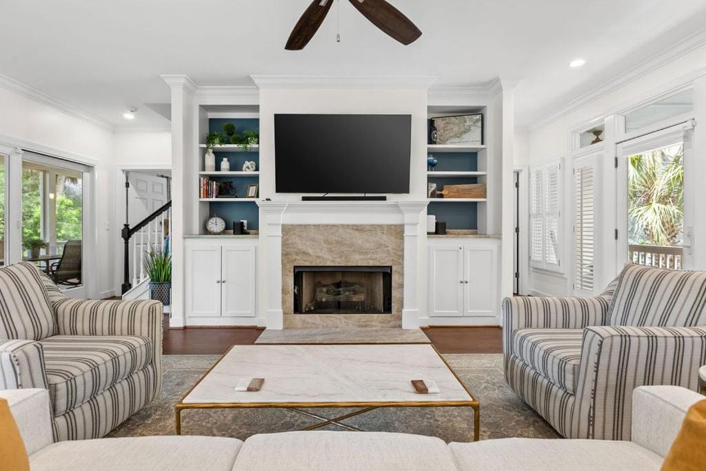 a living room with a fireplace and a flat screen tv at 1005 Crooked Oak Lane in Seabrook Island
